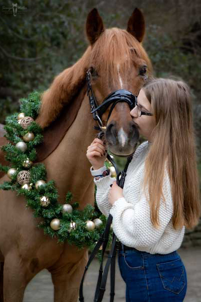 Weihnachtskranz Foto, Junges Mädchen küsst Fuchspony